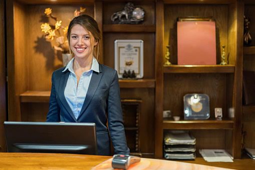 Portrait of smiling hotel receptionist standing at her workplace